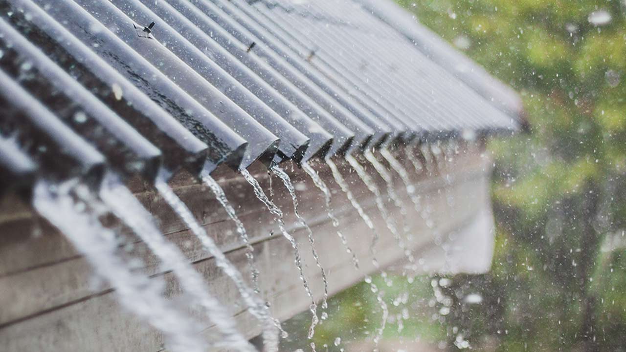 shingles+with+rain+pouring+off+of+them+because+heavy+rain+impacts+your+roof