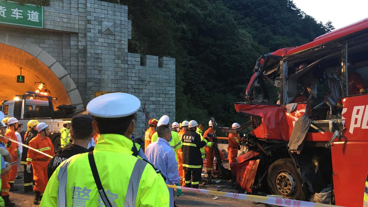 Police and firefighters work near the wreckage of a coach after it crashed into the wall of a tunnel along the Xi’an-Hanzhong expressway in Ankang