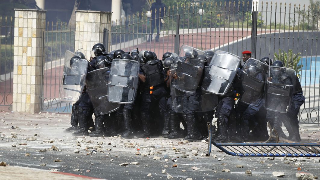 Riot police use their shields against a barrage of stones thrown by protestors in Senegal’s captial Dakar