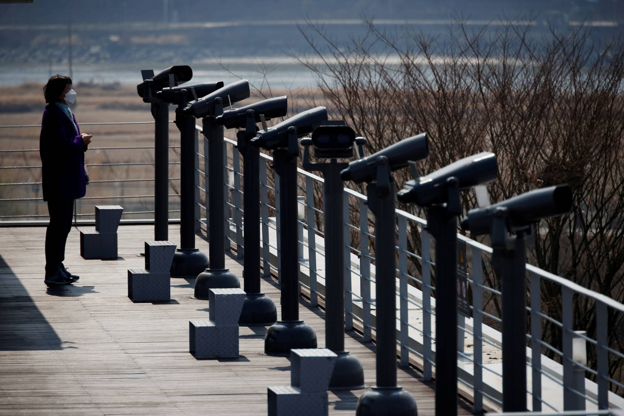 FILE PHOTO: A woman looks toward the north at an observatory platform near the demilitarized zone separating the two Koreas in Paju
