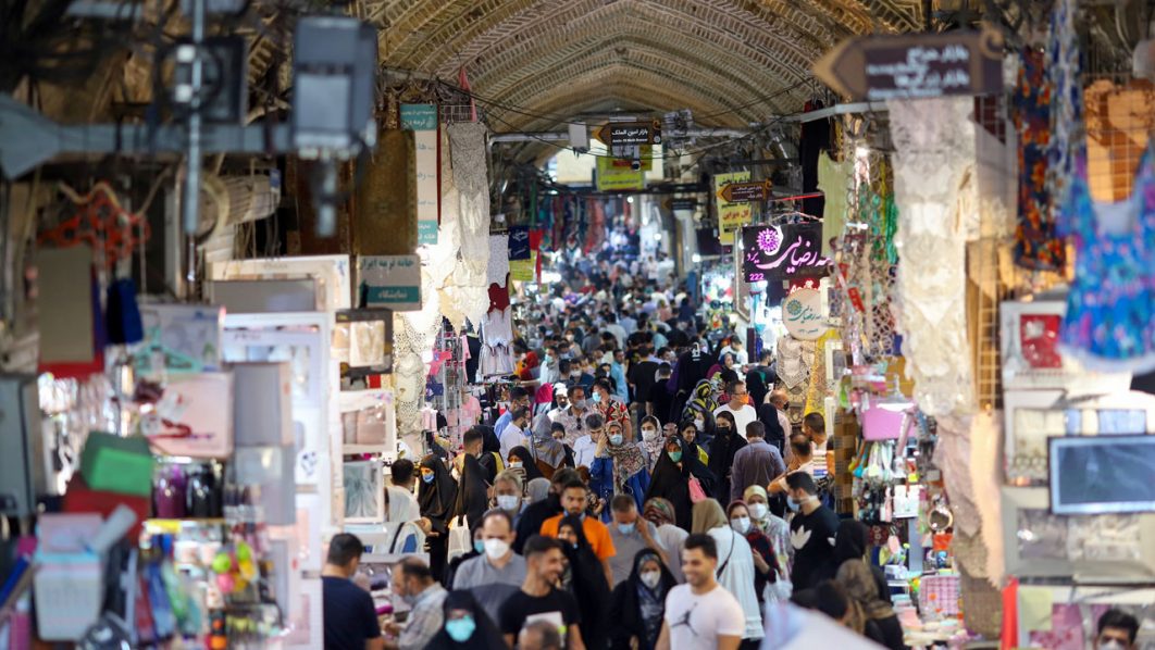 Iranians walk through Tehran Bazaar as coronavirus disease (COVID-19) cases spike, in Tehran