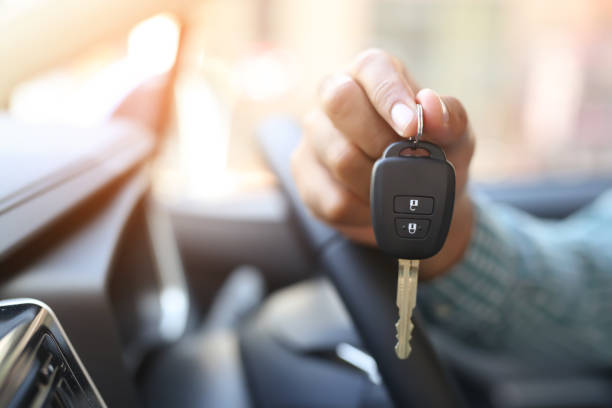 A man’s hand holding a car key