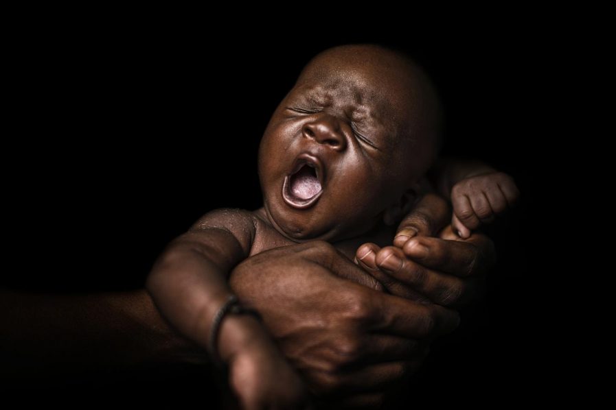 sleeping 24-day-old baby cradled by his mother – UNICEF-UN0188884-Njiokiktjien VII Photo