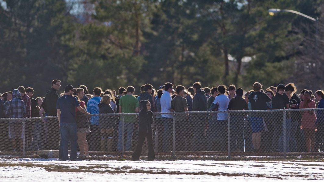 Students gather outside Arapahoe High School, after a student opened fire in the school in Centennial, Colorado