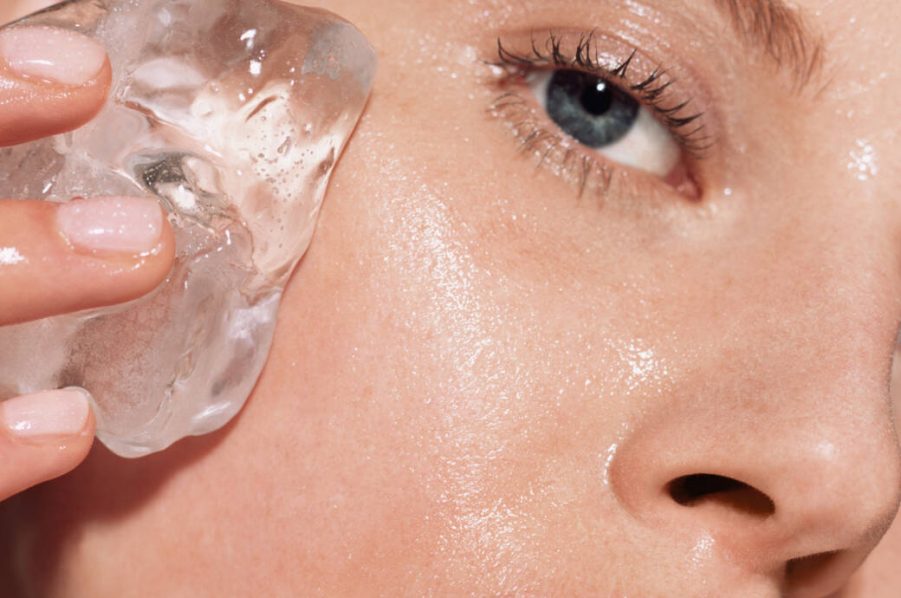 Woman putting ice on her face