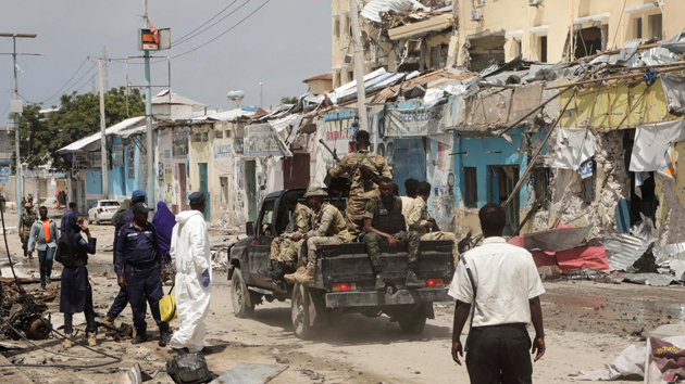 Police and military officials comb the scene of an al Qaeda-linked al Shabaab group militant attack, in Mogadishu