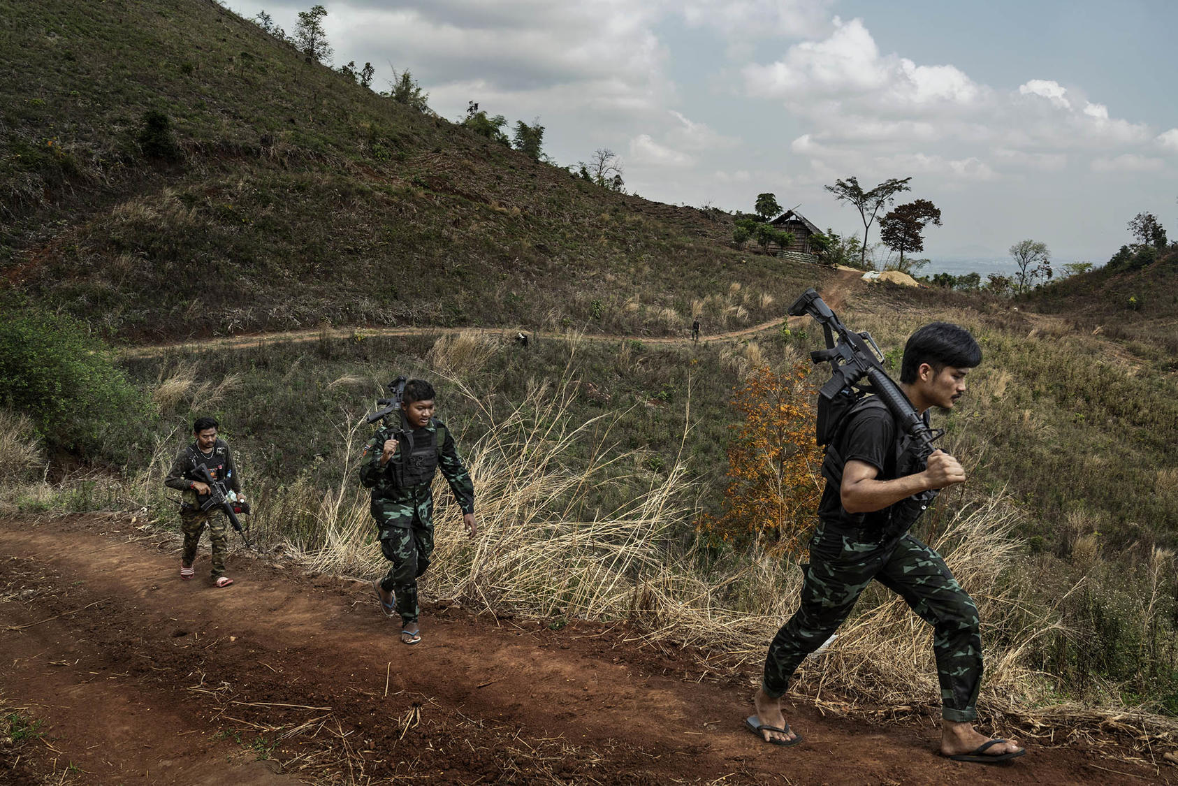 Rebel militia fighters of the People’s Defense Forces, including, at right, a former banquet coordinator for a hotel in Yangon, patrol a front line area near government military positions in the Kayin State of Myanmar, March 9, 2022. (Adam Dean/The New