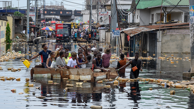 People-cross-the-floodwater-of-the-Carrigres-bridge-in-a-pirogue-in-the-Pompage-district-in-Kinshasa-on-January-9-2024-following-heavy-rains-and-the-flood-of-the-Congo-River-Photo-by-Arsene-Mpiana-AFP