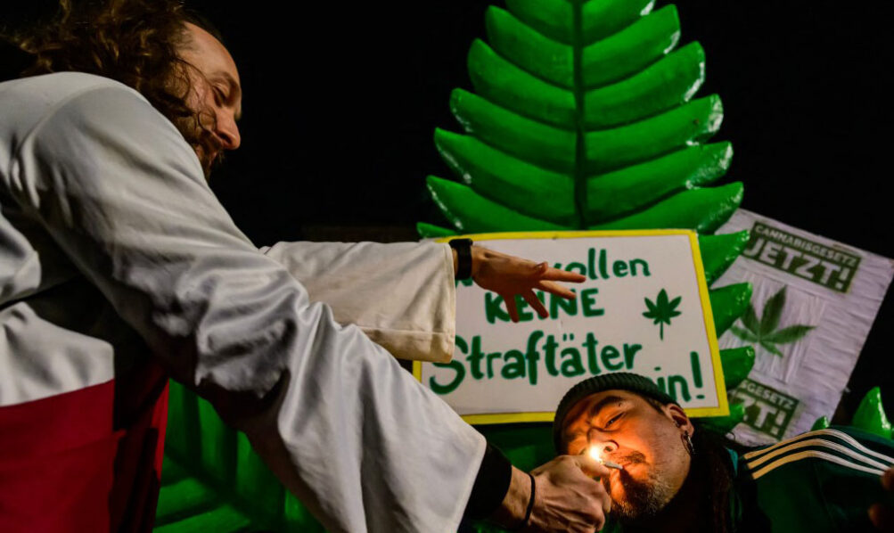People gather to celebrate the law legalising possession and controlled cultivation of cannabis coming into effect