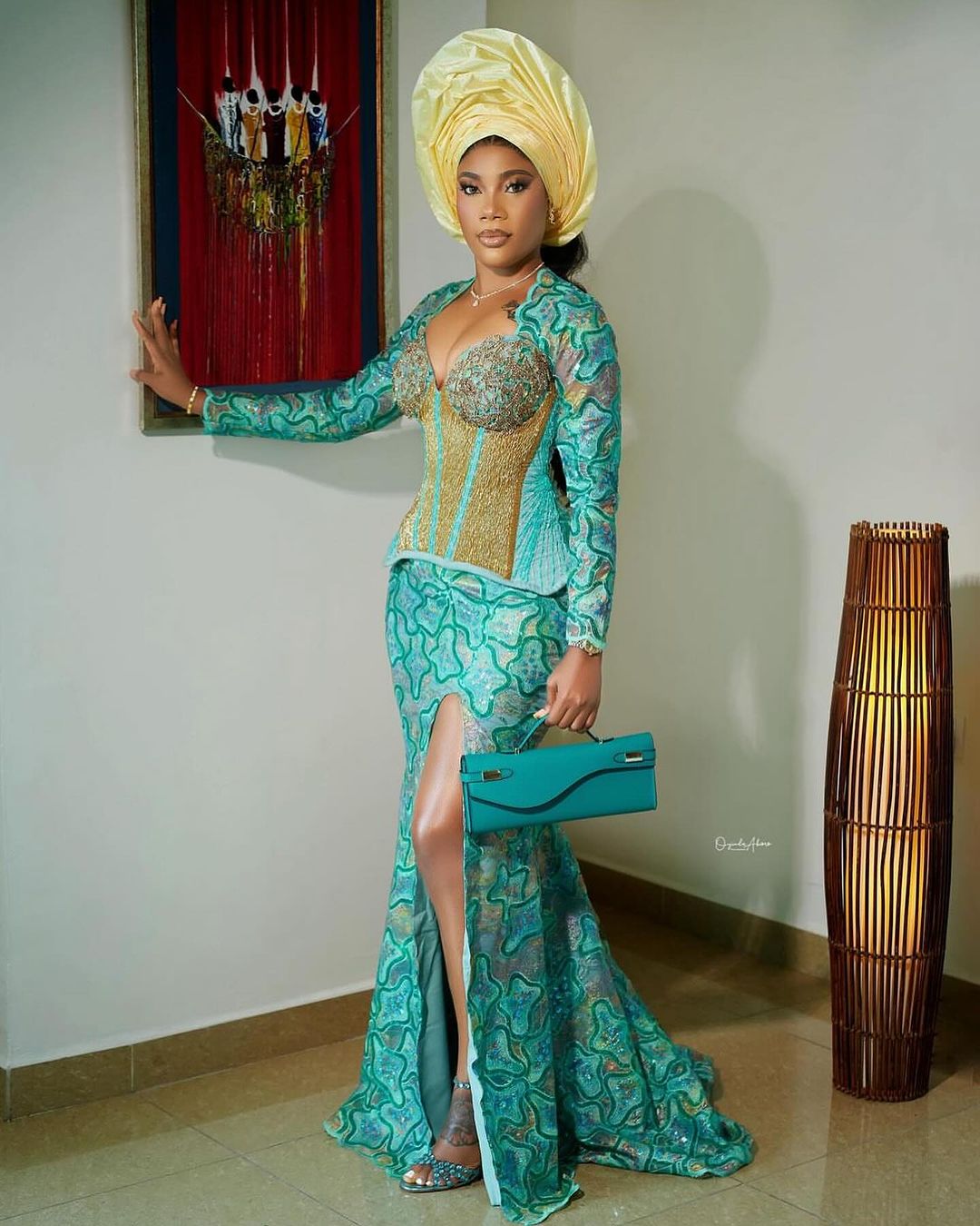 A lady on a traditional attire and a gold head tie (gele)