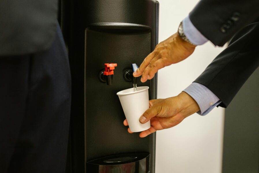 A man taking water from a water dispenser photo by RDNE from Pexels