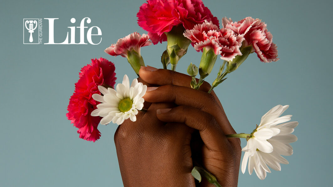 A hand holding colourful flowers