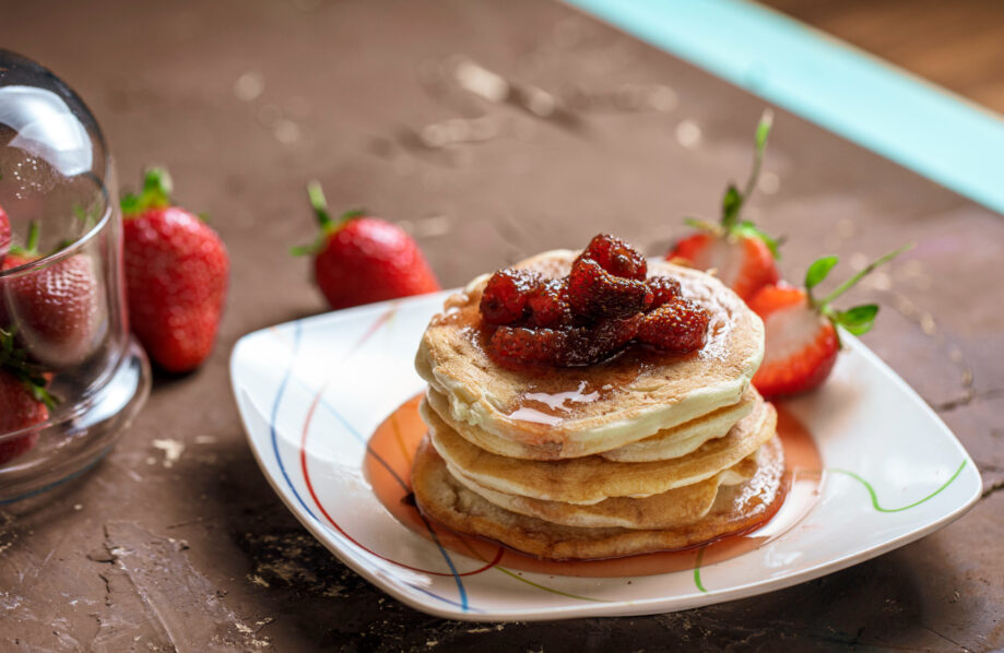 Coconut-banana pancakes with strawberry syrup by Freepik