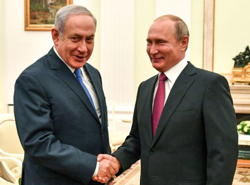 Russian President Vladimir Putin (R) shakes hands with Israeli Prime Minister Benjamin Netanyahu, during a meeting. 