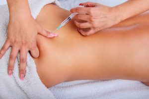 Syringe injection in to woman’s back.