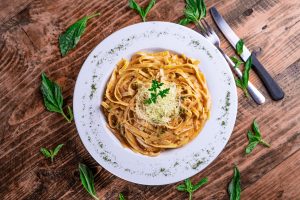 Top view of a cheesy pasta on a white plate