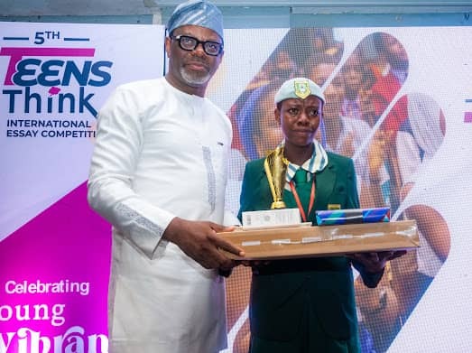 Keynote speaker, Dr Celestine Achi, presenting the first prize to the winner, Opabiyi Josephine, of Federal College of Education Abeokuta, Model Secondary School, Abeokuta, Ogun State.