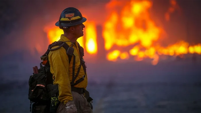 A Mountain View wildland firefighter walks through the smoke and haze