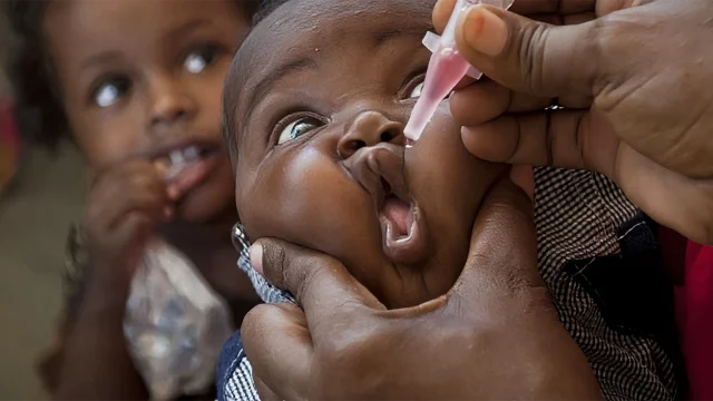 A Pediatric nurse administered Polio vaccine  to a baby.