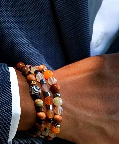 Person wearing a beaded necklace around their hand