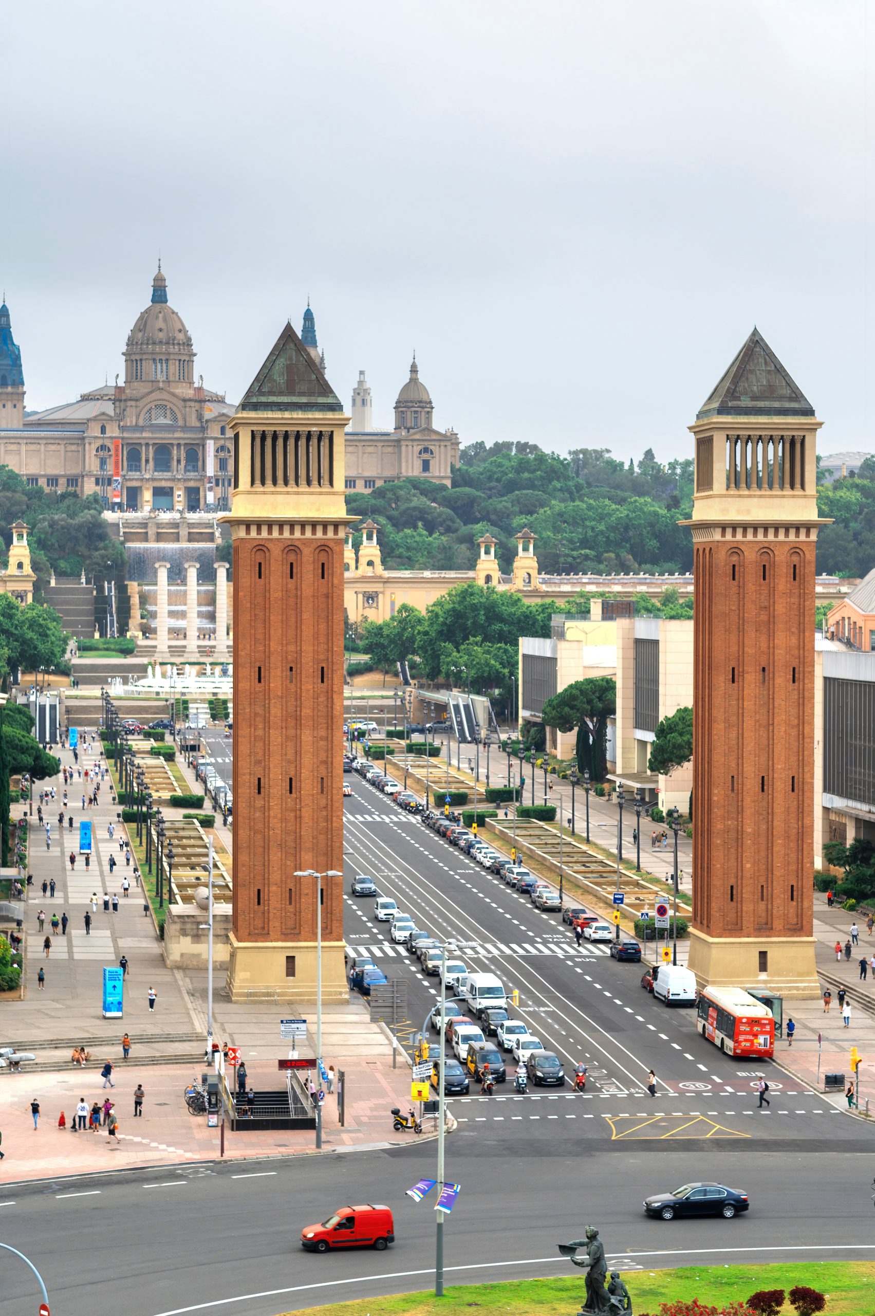 Plaza de Espana, The Venetian Towers and The Palau Nacional in Barcelona, Spain. Cloudy sky, traffic