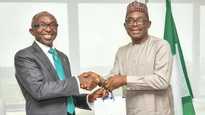 Managing Director Chief Executive, Ministry of Finance Incorporated (MOFI), Dr Armstrong Takang (left) receives NDIC publications from Managing Director Chief Executive, NDIC, Thompson Oludare Sunday