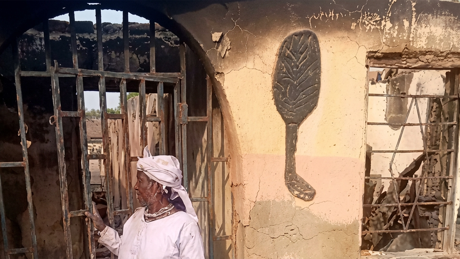 Olorisa in front of the burnt building
