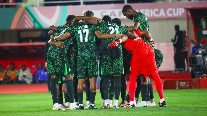 Super Eagles players come together in a huddle before their AFCON 2025 match against Tanzania.
