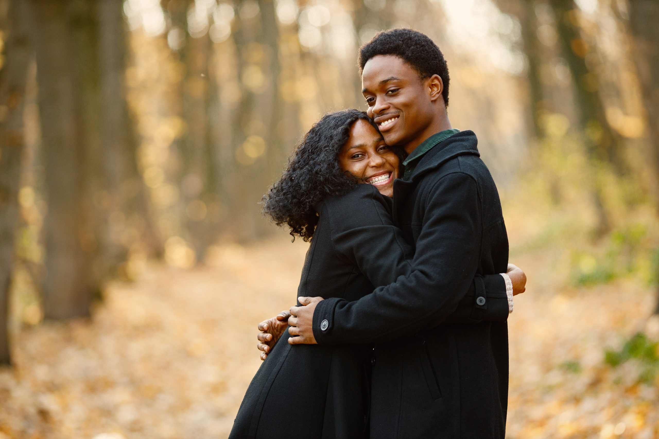Black young man and his girlfriend hugging. Romantic couple. walking in autumn park. Photo by Freepik