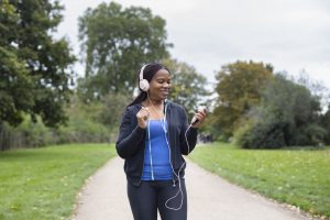 Woman walking with headphones. Photo by Freepik