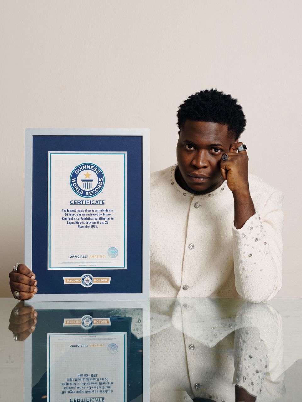 Nigerian magician FaddotheGreat, Ibitoye Kingfahd, holds his Guinness World Records certificate for longest magic show.