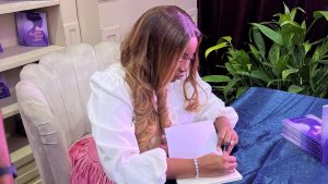 Ada Onanuga autographs a copy of her book 'Awaken the Voice Within'