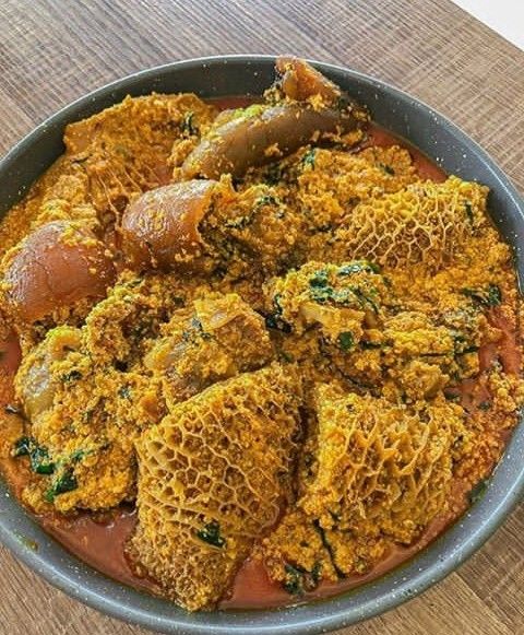 Bowl of Nigerian egusi soup with assorted meat, cow skin and tripe in a rich peppered stew base.