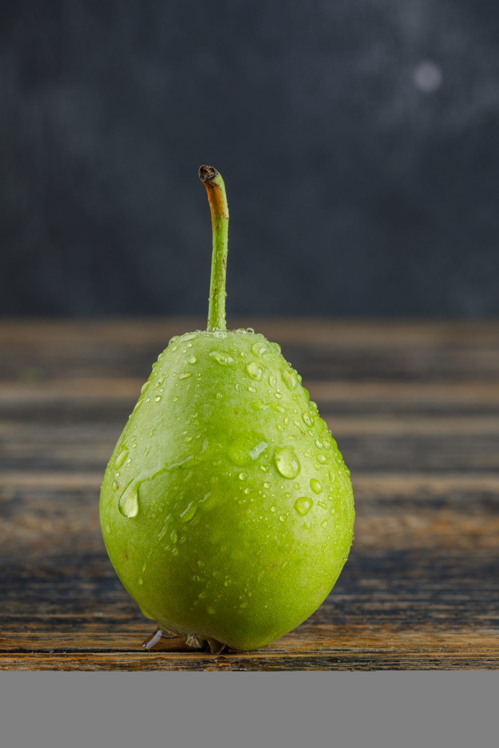 Ripe pear side view on wooden and grey background