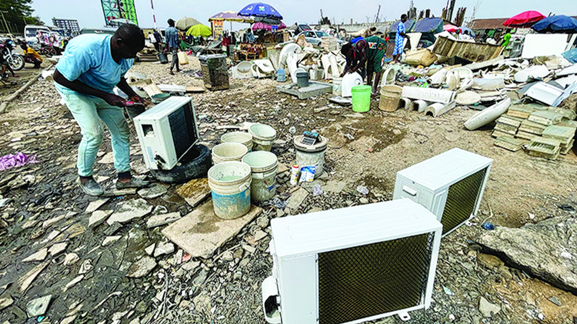 A technician revamps a scrapped air conditioner, marketing each for N300,000 ($200) at the Jabi Motor Park in Abuja, where residents with low purchasing power, particularly the low and middle income earners scout used items. PHOTO: KINGSLEY JEREMIAH