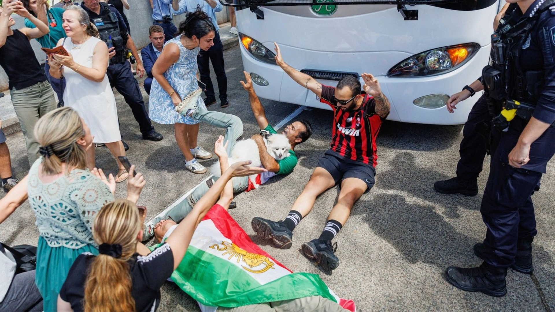 People protest in front of a bus conveying the Iranian women’s national team.