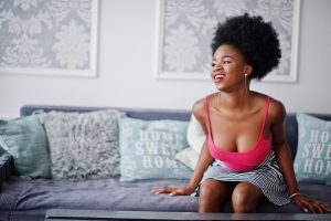 Young woman smiling on sofa. Photo Freepik