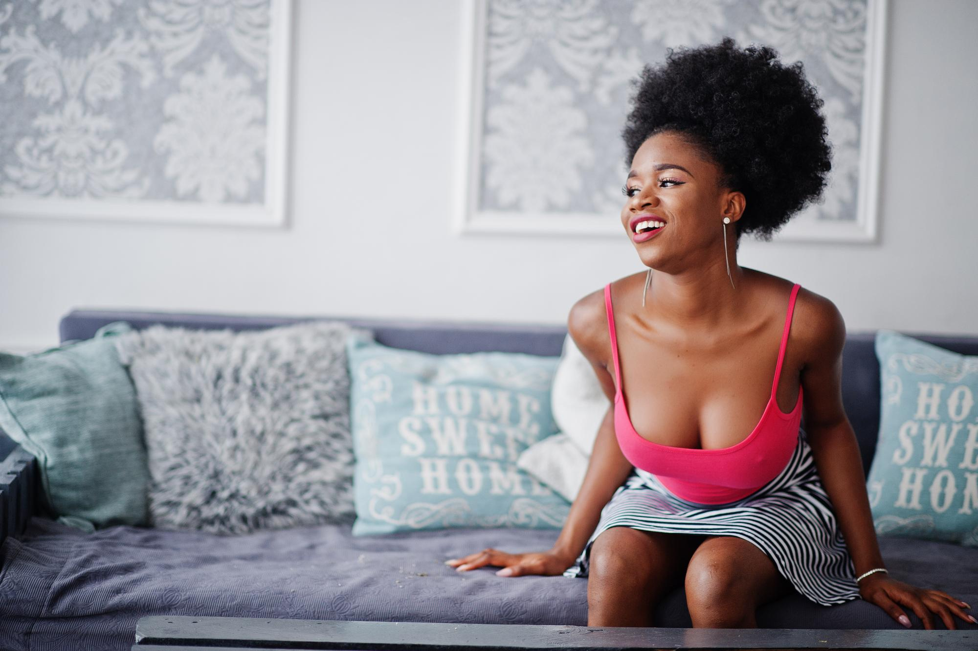 Young woman smiling on sofa. Photo Freepik