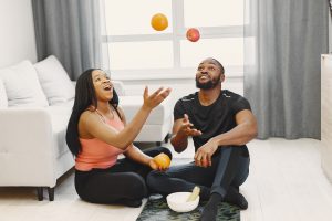 Handsome Afro American couple sitting with fruitsat home