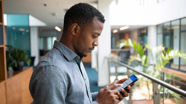 Young Investor analyzing his profits on the phone