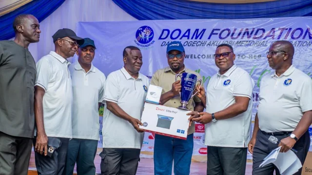 CAPTION: Eight-handicapper, Mike Makinde, receives DOAM Foundation Golf trophy from the organizers (edited)