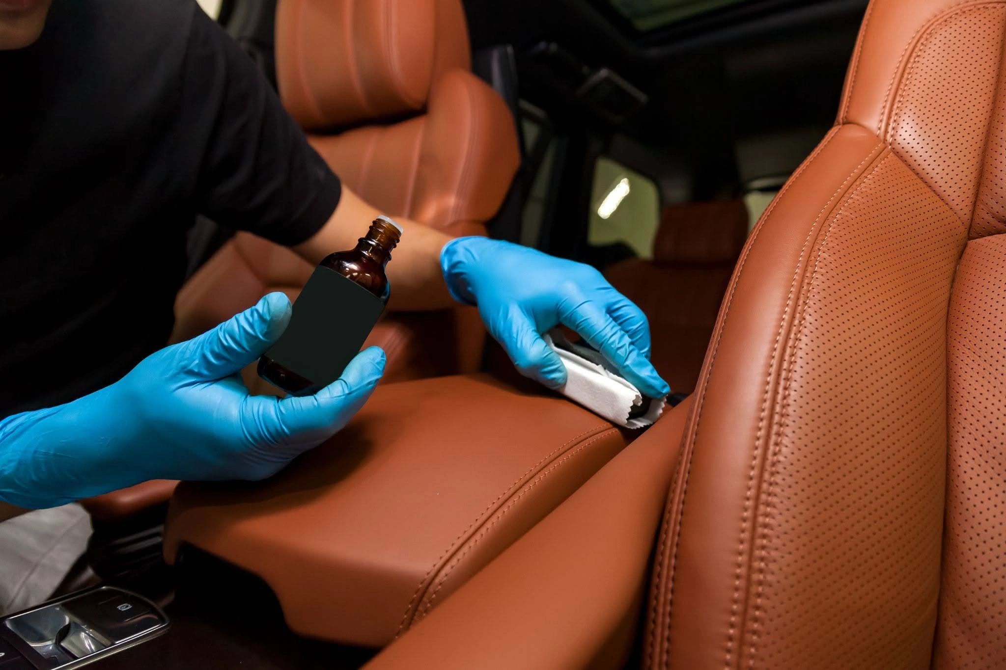 A person applying ointment to a car seat