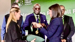 Drew Uyi (middle) receives his award at the 2026 Hungary Football Forum