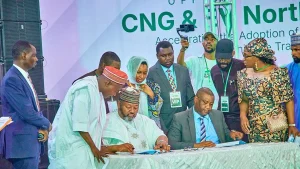 Ismael Ahmed, Executive Chairman, Presidential Compressed Natural Gas Initiative (PCNG); and Mr. Nazif Ibrahim, Regional Head Northeast and Northwest, LOTUS Bank; signing the PCNG initiative partnership agreement while other dignitaries watch in Kano, Kano State.