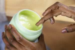 high-angle-hand-holding-cream-container