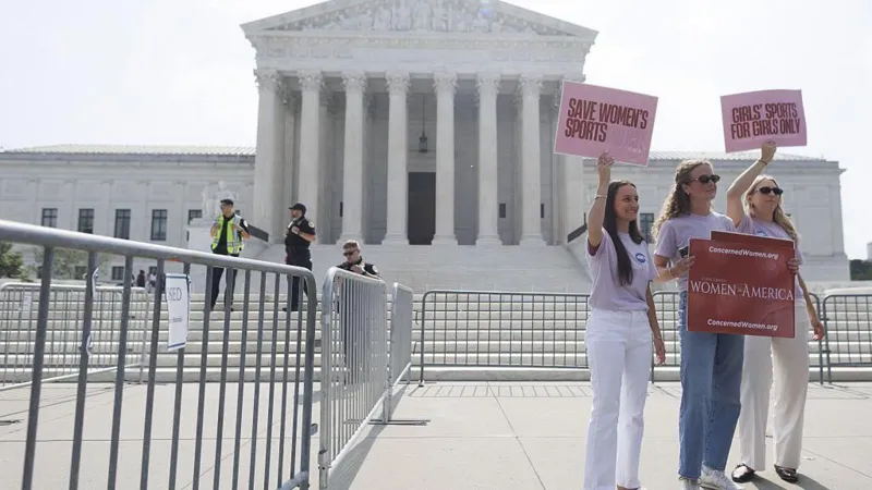 Supporters of banning trans athletes from women’s and girls’ sports hold signs outside the US Supreme Court this week
