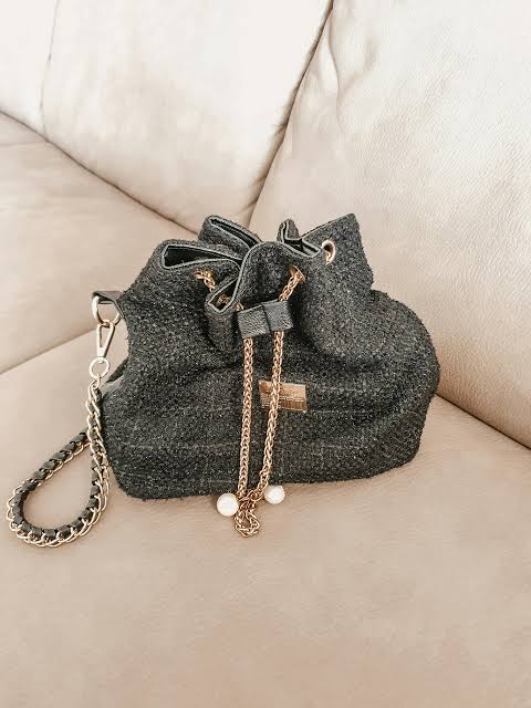 Stylish bucket bag with a textured pattern and elegant design, suitable for both casual and formal wear.