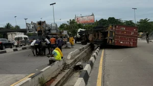 Driver, assistant flee scene after container truck falls near Oshodi flyover