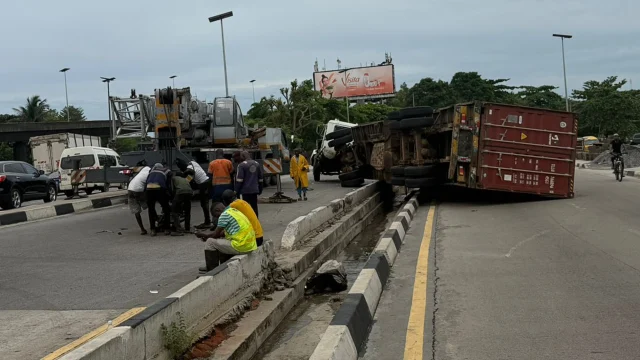 Driver, assistant flee scene after container truck falls near Oshodi flyover
