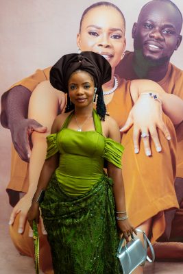 A stylish young woman showcasing the elegance and cultural richness of Aso Ebi fashion.